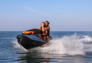 Two girls having fun on the water riding a jet ski