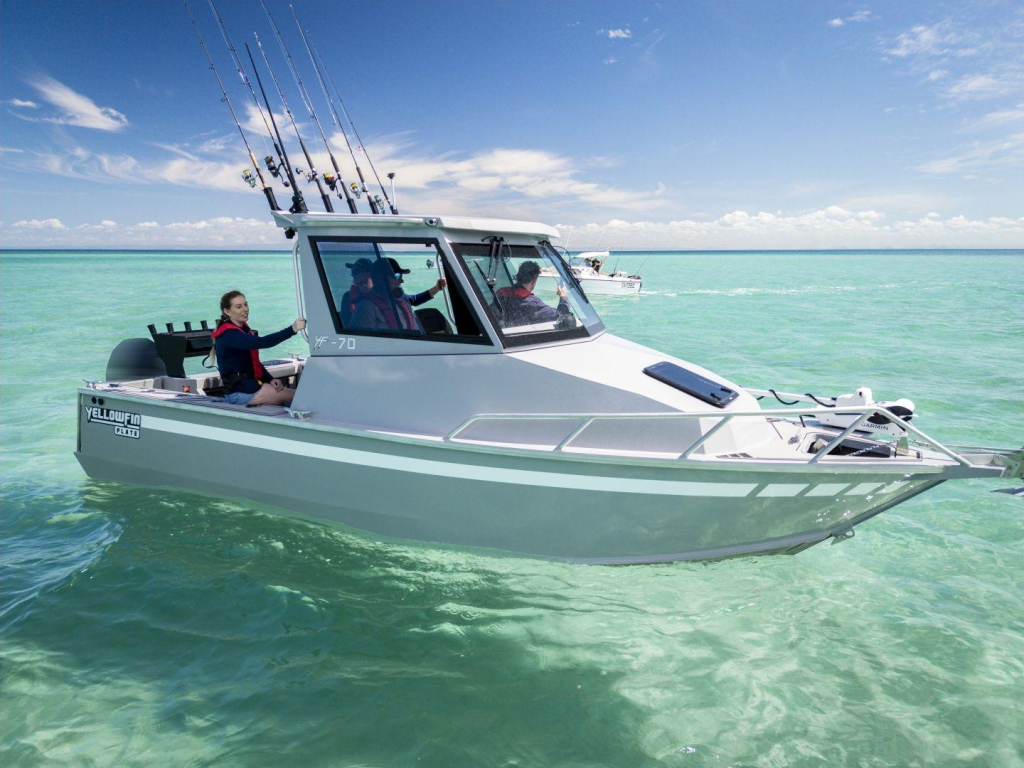 The YF70 Extended Cab boat floating on calm waters with 4 people on board.