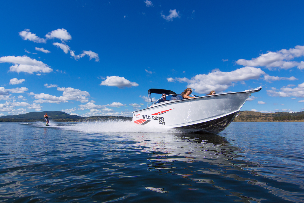 The 539 Wild Rider SE boat out on the open water pulling a skier behind on a sunny day.