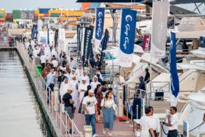 Crowds of people walking along a wharf, looking at boats on show