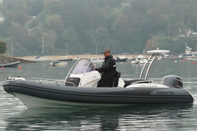 Grand G580 RIB boat, a compact option, with a man driving it on the water, ideal for coastal use.