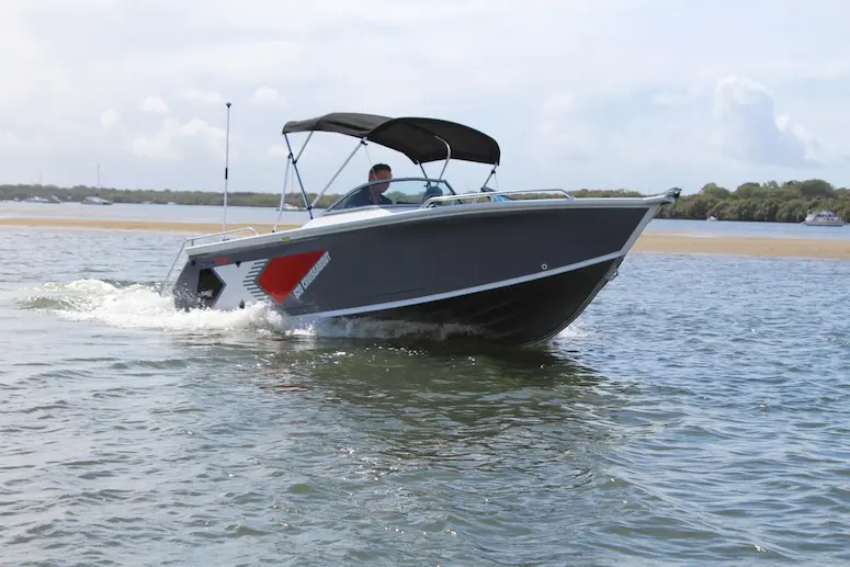 A big-value budget boat for 2026, the 510 Cruiseabout, on the water with a person driving.